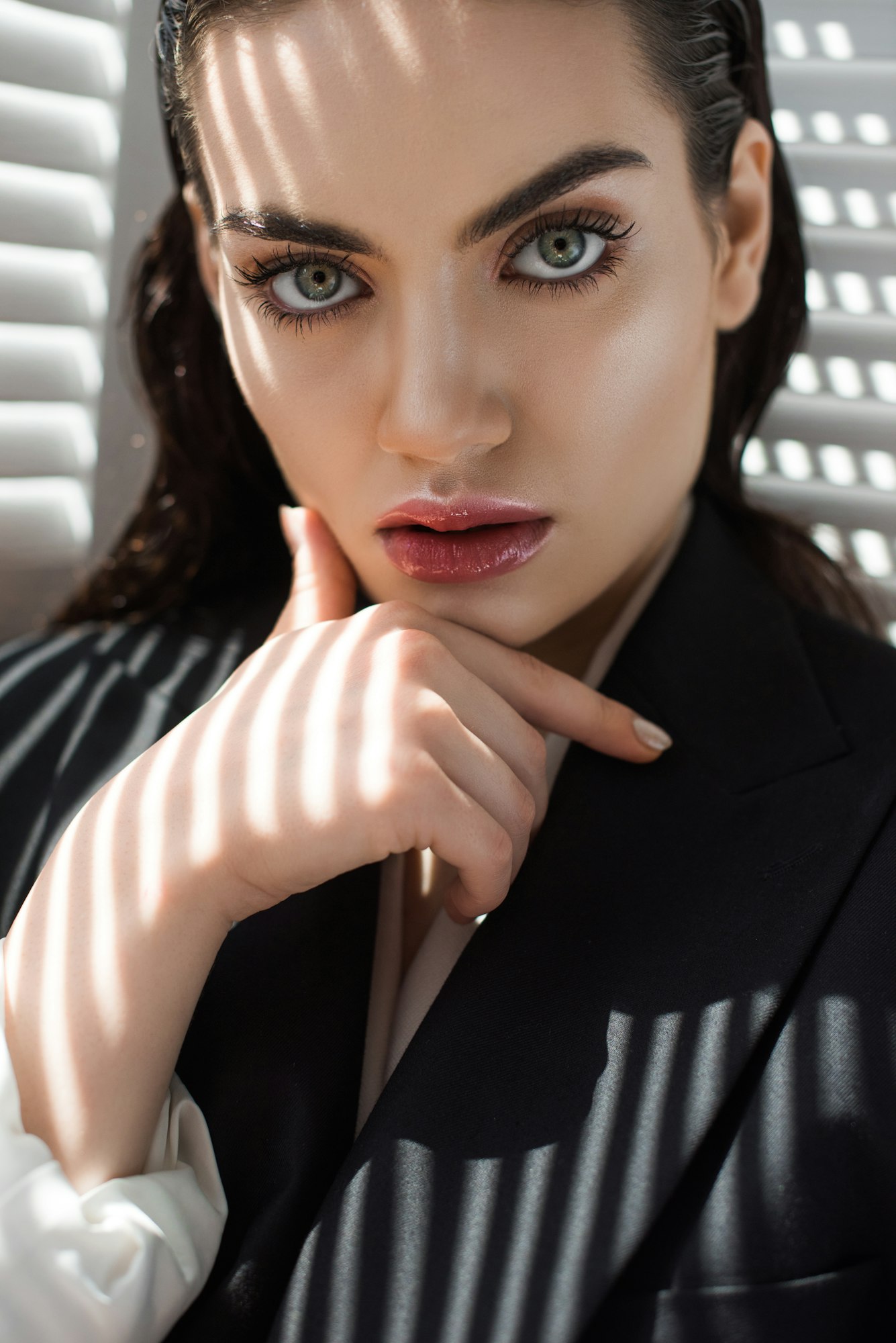 fashionable lady with makeup in black jacket with shadows on face